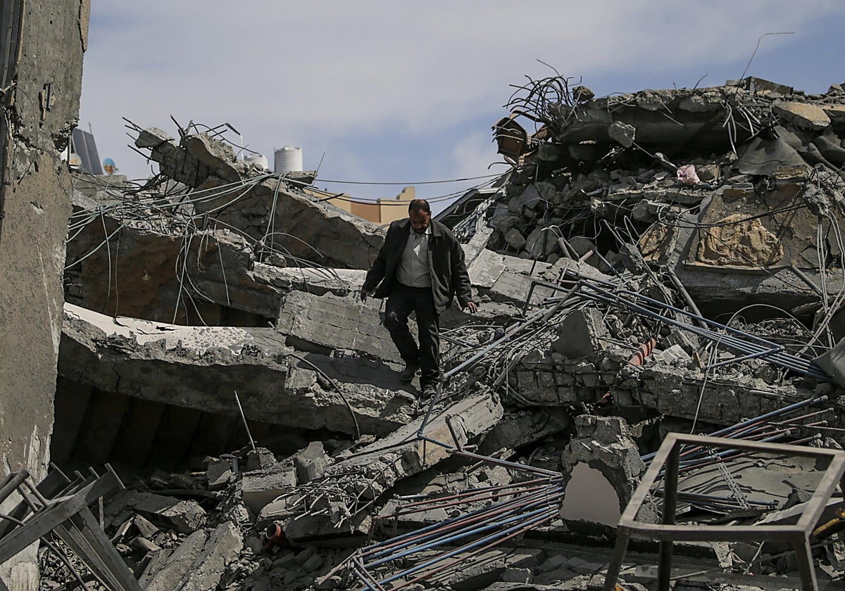 Un hombre camina entre las ruinas de un edificio bombardeado de Jan Yunis