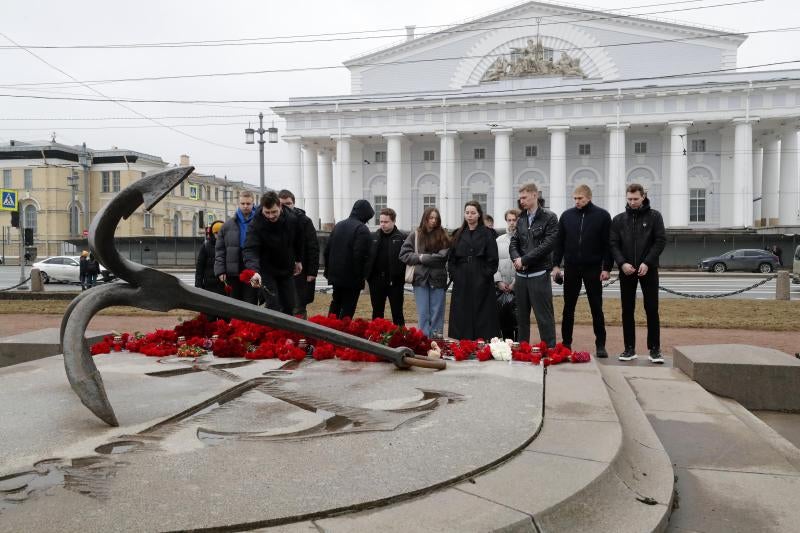 La gente llora y deposita flores en un monumento conmemorativo en San Petersburgo, Rusia