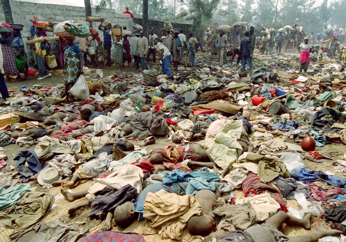 En esta fotografía del 18 de julio de 1994, refugiados ruandeses pasan junto a los cadáveres de más de cien compatriotas, que fueron pisoteados en la entonces ciudad fronteriza de Goma