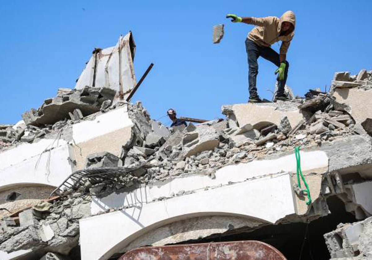 Un hombre busca entre las ruinas de edificios destruidos en Ciudad de Gaza