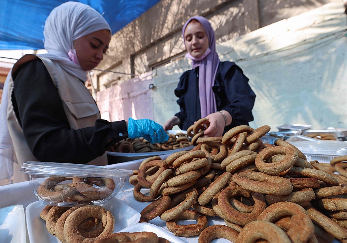 Dos mujeres palestinas preparan en Rafah dulces para celebrar el final del ramadán
