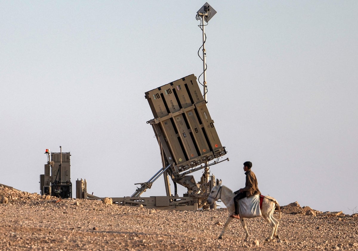 Un niño monta un burro cerca de una de las baterías del sistema de defensa antimisiles Cúpula de Hierro de Israel