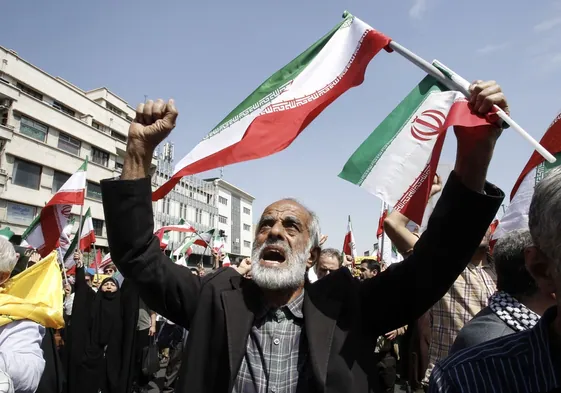 Los iraníes gritan consignas y ondean banderas iraníes durante una manifestación contra Israel en Teherán, Irán