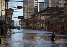 Un hombre camina por una calle inundada en el centro histórico de la ciudad de Porto Alegree
