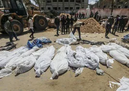 Un grupo de sanitarios recupera cuerpos enterrados en el Hospital Nasser