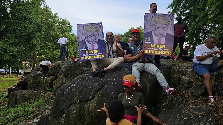 Varios partidarios de Trump sostienen carteles con su rostro durante el discurso en el Bronx