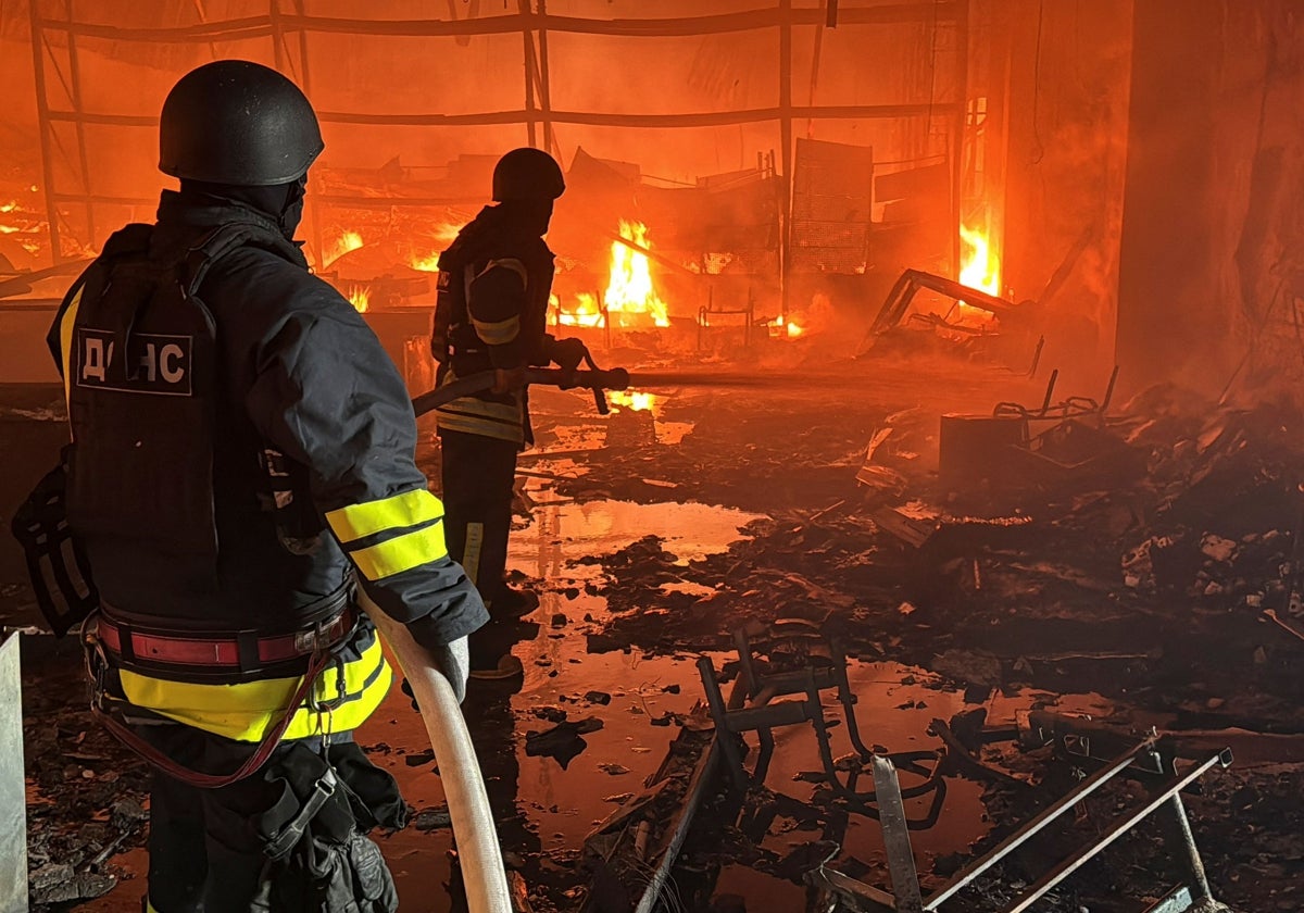 Los bomberos se esfuerzan en apagar las llamas provocadas por el bombardeo