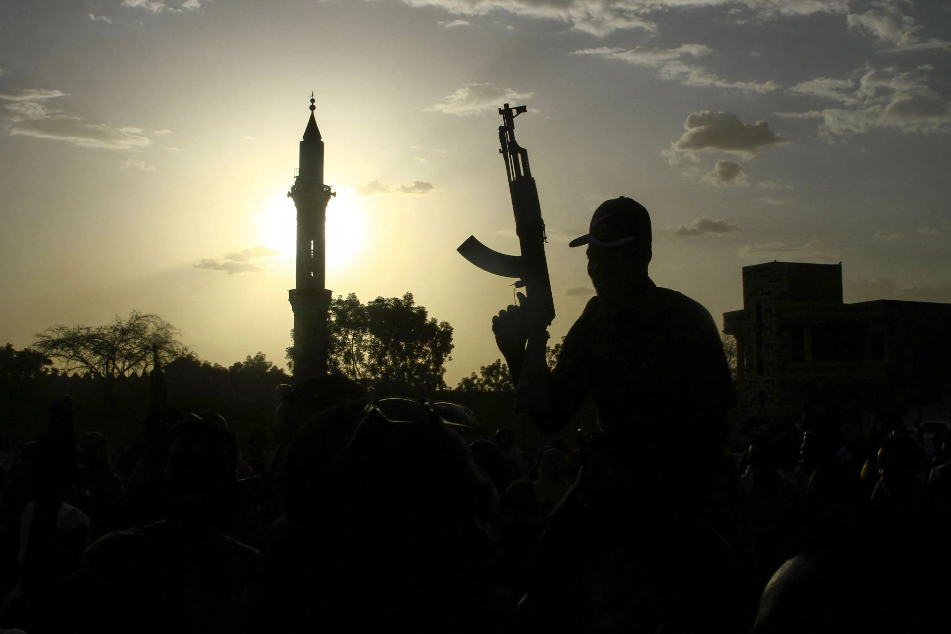 Un soldado leal al jefe del Ejército de Sudán, Abdel Fattah al Burhan, sostiene un arma con el minarete de una mezquita como telón de fondo