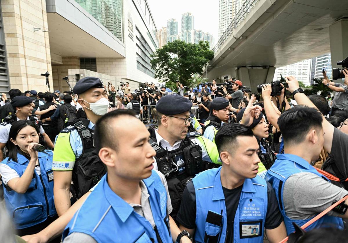 La policía intenta controlar al personal de los medios de comunicación fuera del Tribunal de Magistrados de West Kowloon