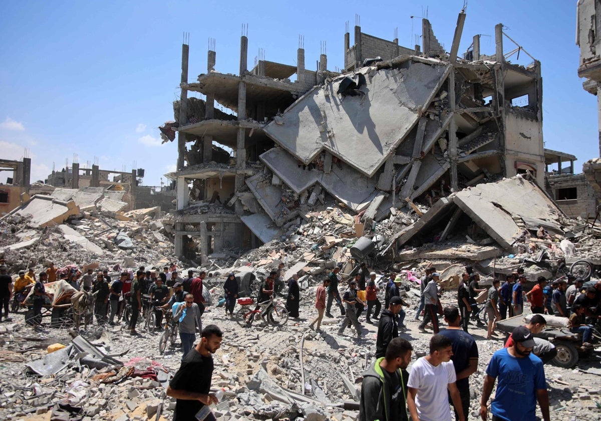 Los palestinos cargan algunas pertenencias recuperadas cuando abandonan el campo de refugiados de Jabalia en el norte de la Franja de Gaza