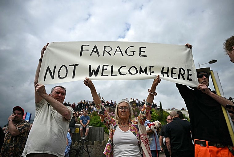 Manifestantes sostienen una pancarta que dice «Farage no es bienvenido aquí»