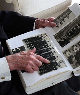 Imagen secundaria 2 - John Roberts mira un álbum de fotografías de su servicio durante la Segunda Guerra Mundial