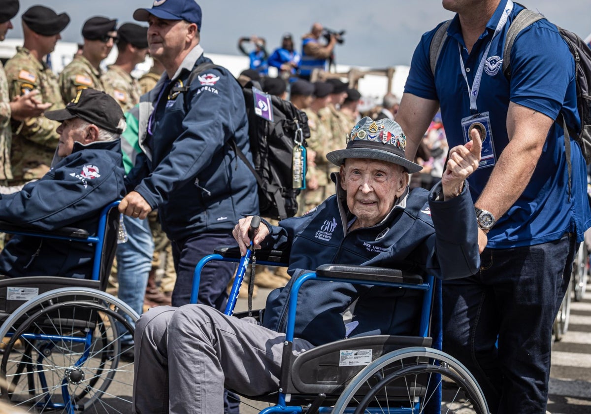 Jake Larson saluda a la multitud a su llegada al aeropuerto durante una ceremonia de bienvenida para los 60 veteranos estadounidenses que llegan para participar En el 80º aniversario del Día D
