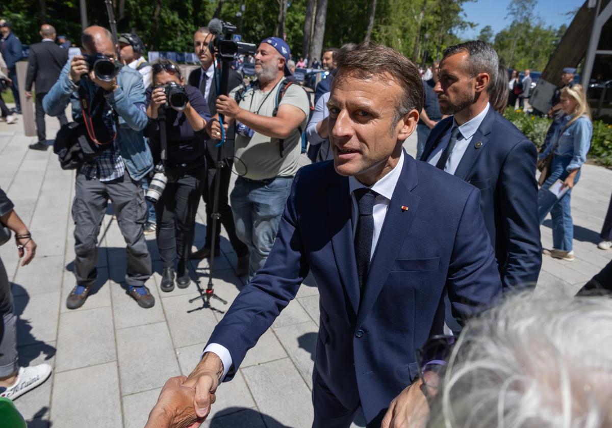 El presidente francés, Emmanuel Macron (al frente), saluda a los residentes fuera de un colegio electoral después de votar para las elecciones al Parlamento Europeo en Le Touquet