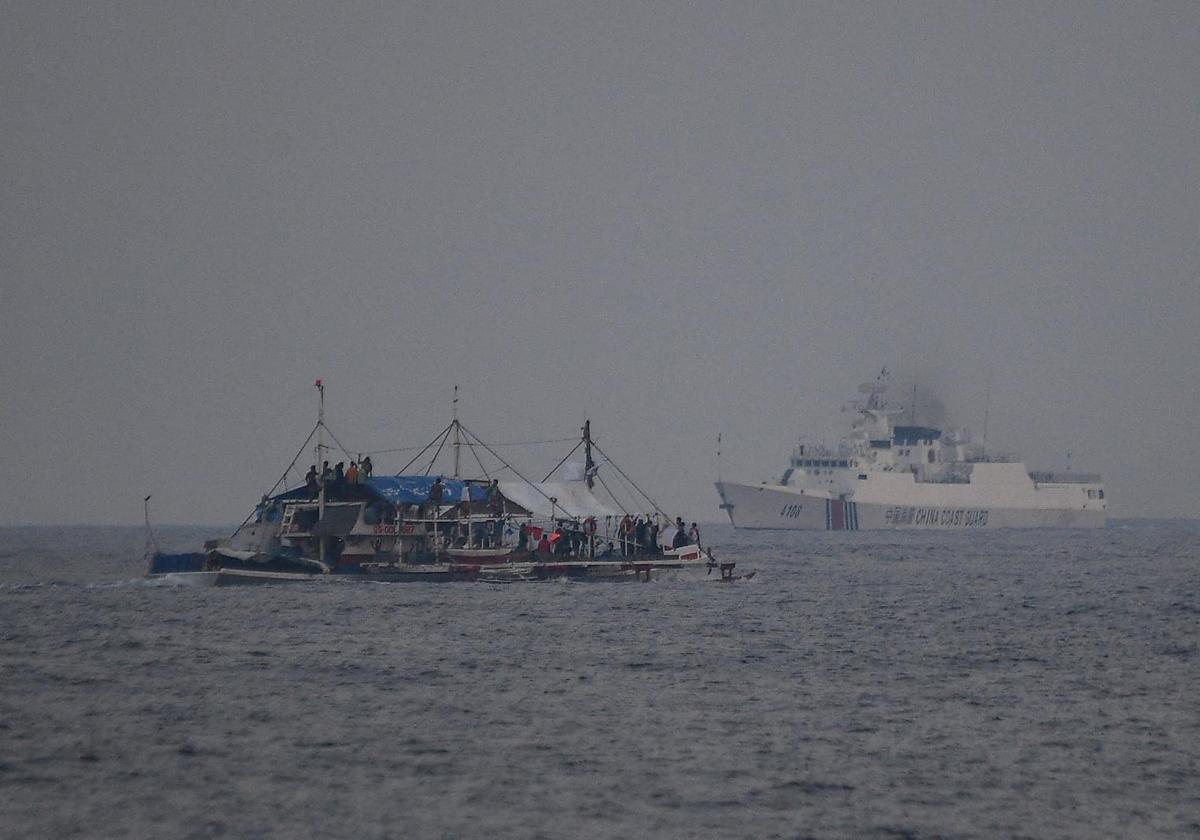 Un barco de la Guardia Costera de China (R) navegando junto a un barco pesquero filipino en mayo