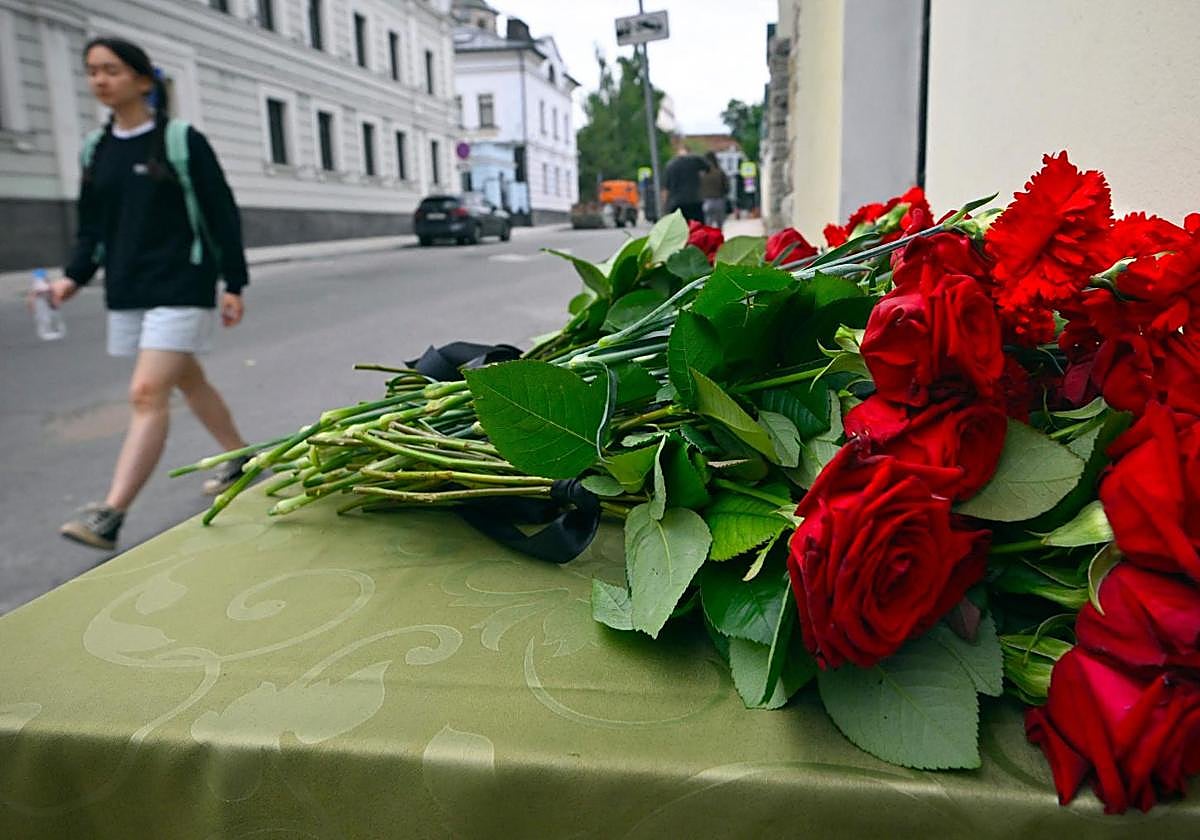 Un hombre pasa junto a las flores colocadas frente a la oficina de representación de Daguestán en Moscú