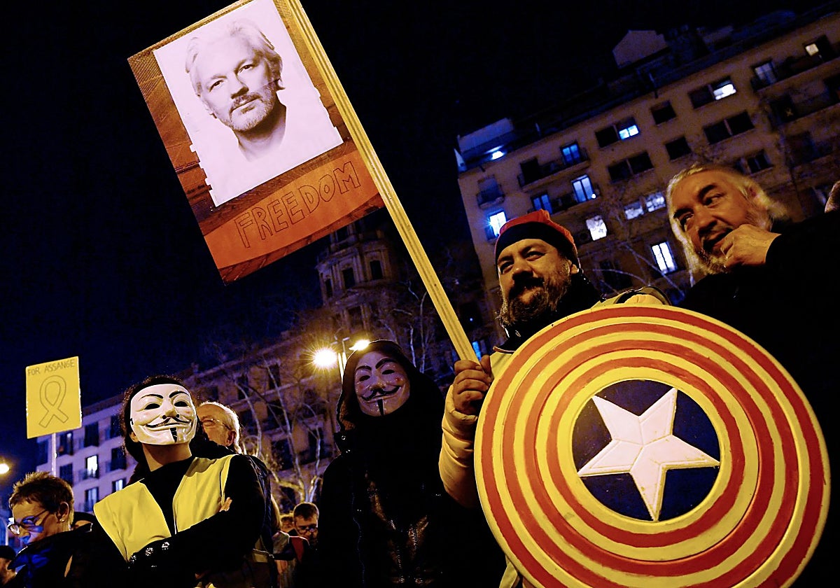 Un manifestante independentista sostiene una pancarta con el rostro de Assange en Barcelona