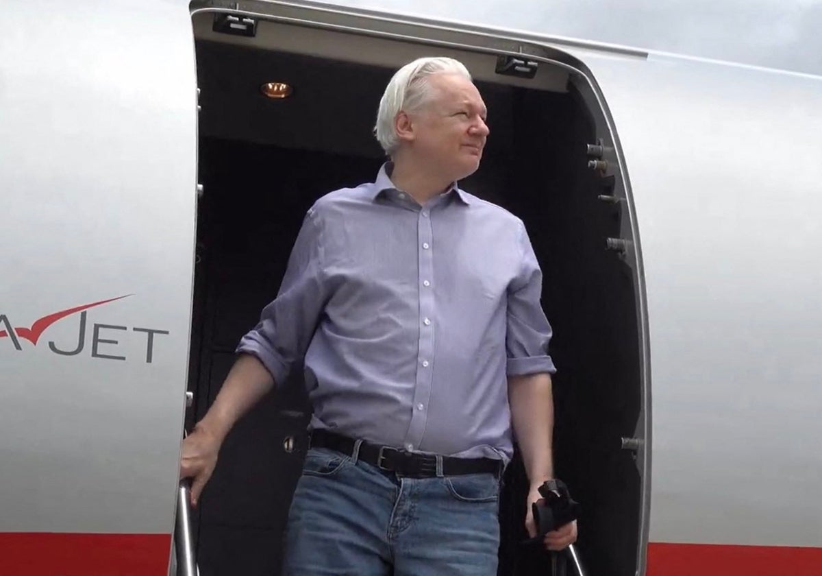 Jlian Assange desciende este martes de su vuelo procedente de Londres a su llegada a Bangkok para hacer escala en el aeropuerto internacional Don Mueang de la capital tailandesa