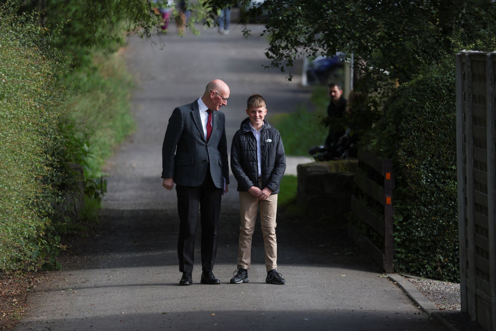 El líder del Partido Nacional Escocés (SNP), John Swinney, mira a su hijo Matthew fuera de un colegio electoral