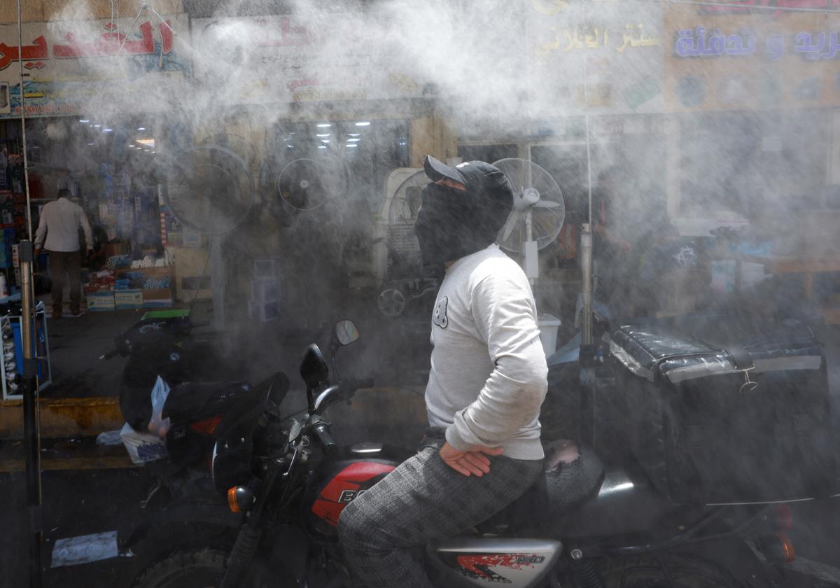 Un hombre en motocicleta combate el calor en Bagdad. Imagen de archivo