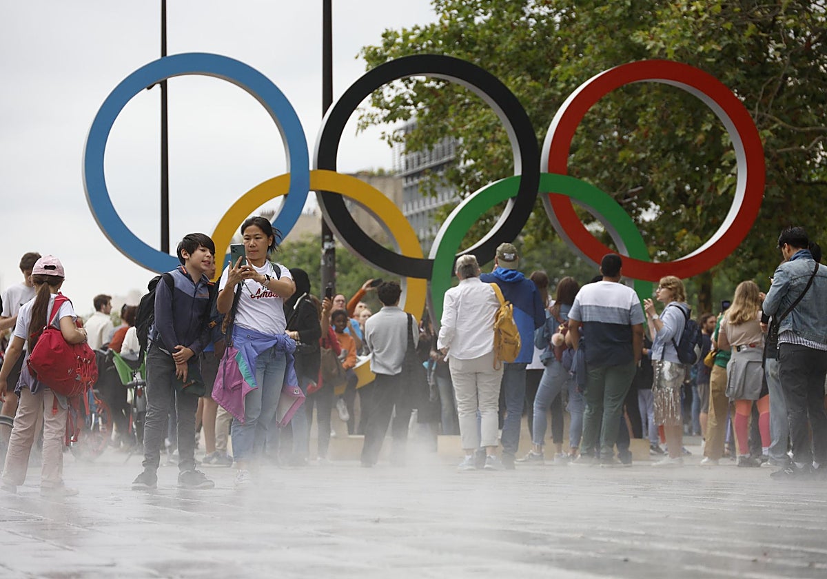 Espectadores frente al logo de los Juegos Olímpicos en París