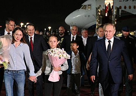 Imagen secundaria 1 - En la foto de arriba se ve a Pablo González bajando del avión, con camiseta negra. Debajo, comitiva de prisioneros canjeados junto a Putin. En la foto pequeña, Pablo González al fondo, con camiseta negra