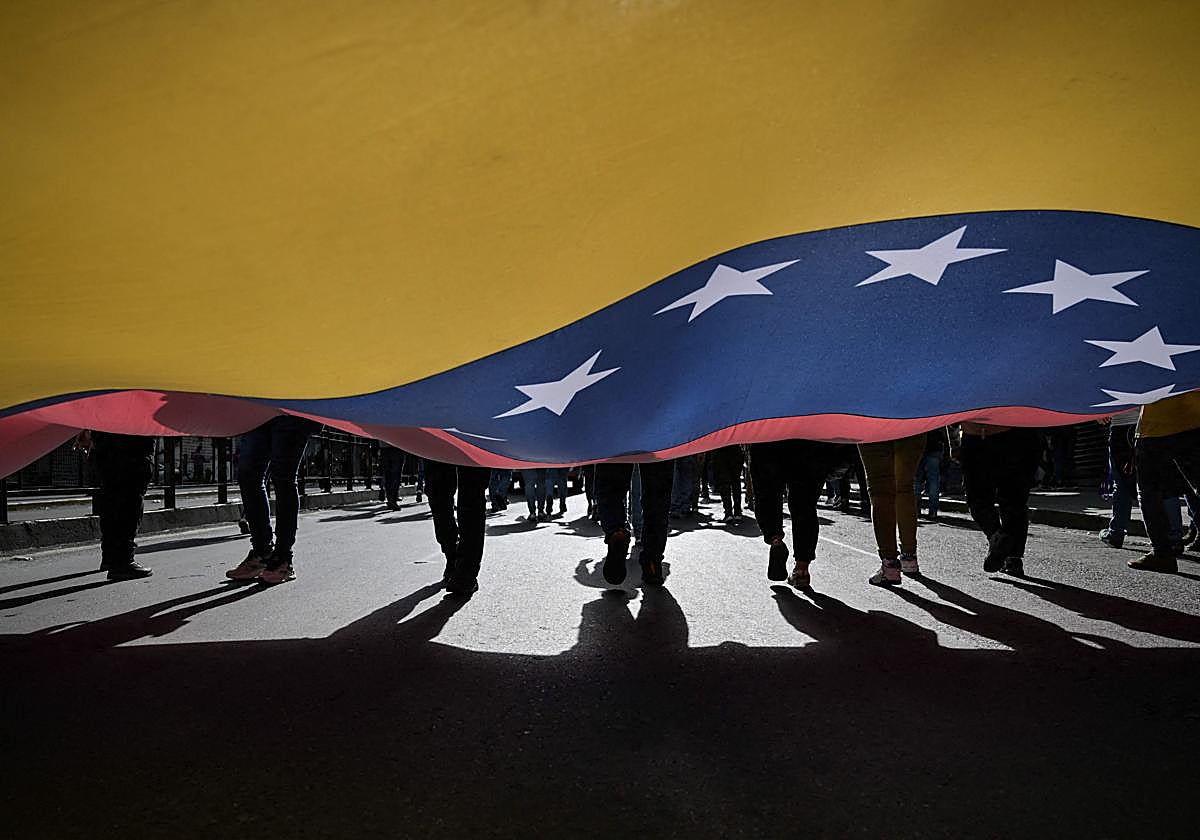 Simpatizantes del presidente de Venezuela, Nicolás Maduro, muestran una bandera venezolana durante un mitin en Caracas el 31 de julio de 2024