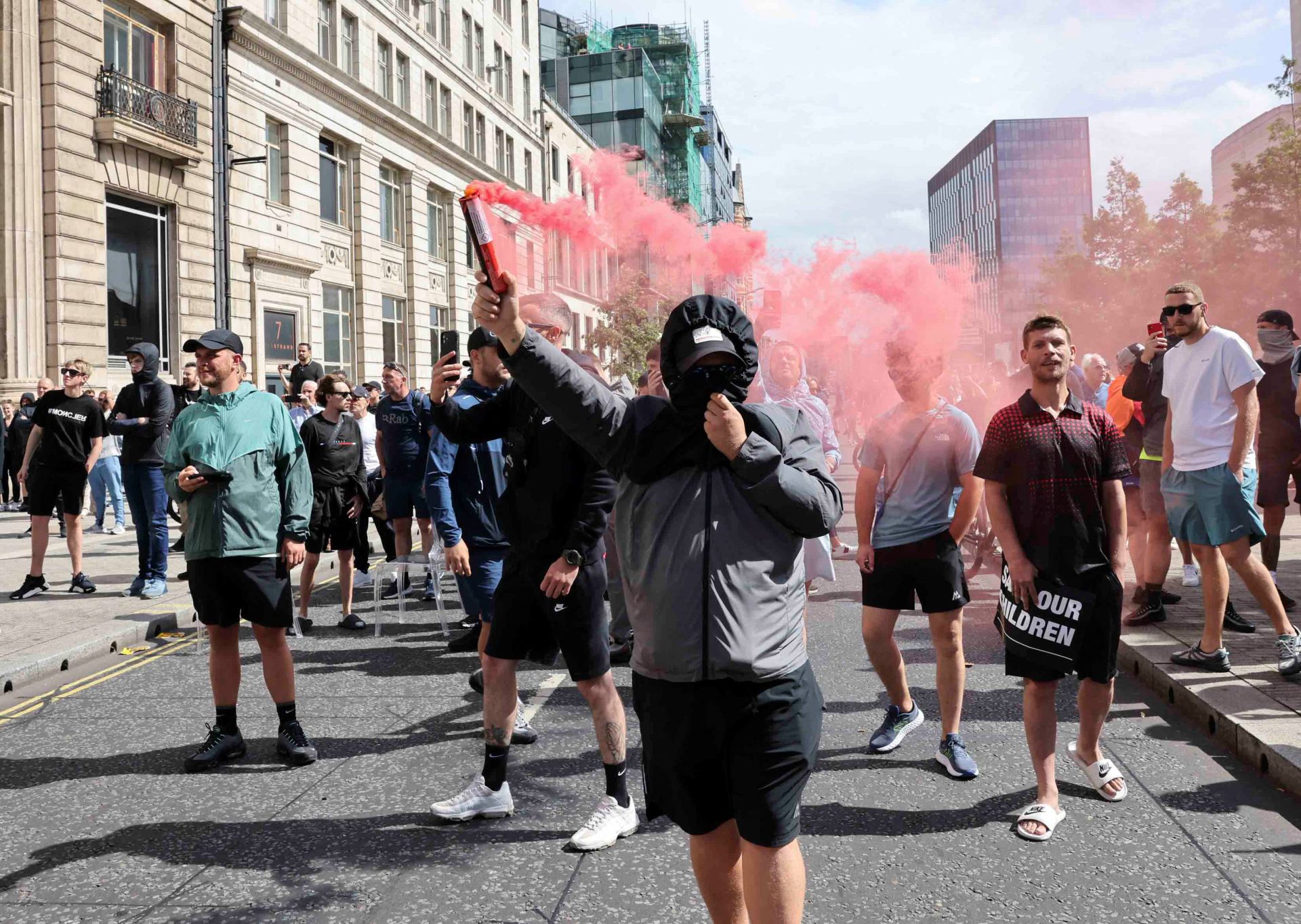 Un manifestante sostiene una bengala durante una protesta contra la inmigración en Liverpool.