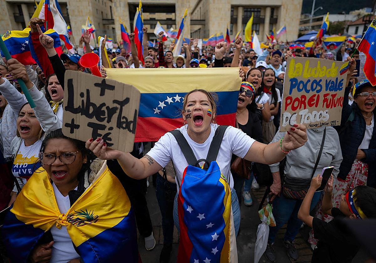Manifestantes muestran eslóganes en contra de Maduro