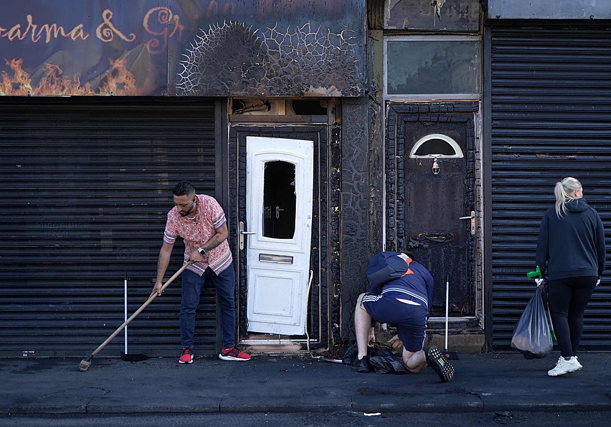 El propietario de un restaurante incendiado en Middlesbrough, Luqman Khan, realiza tareas de limpieza