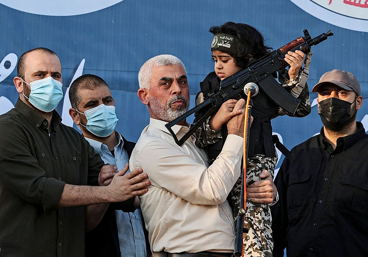 El líder de Hamas en la Franja de Gaza, Yahya Sinwar, sostiene al hijo de un combatiente de las Brigadas Al-Qassam