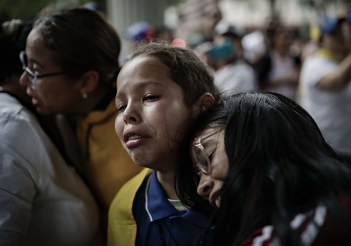 Dos jóvenes venezolanas lloran tras conocer los resultados del oficialismo que otorgan la victoria a Maduro