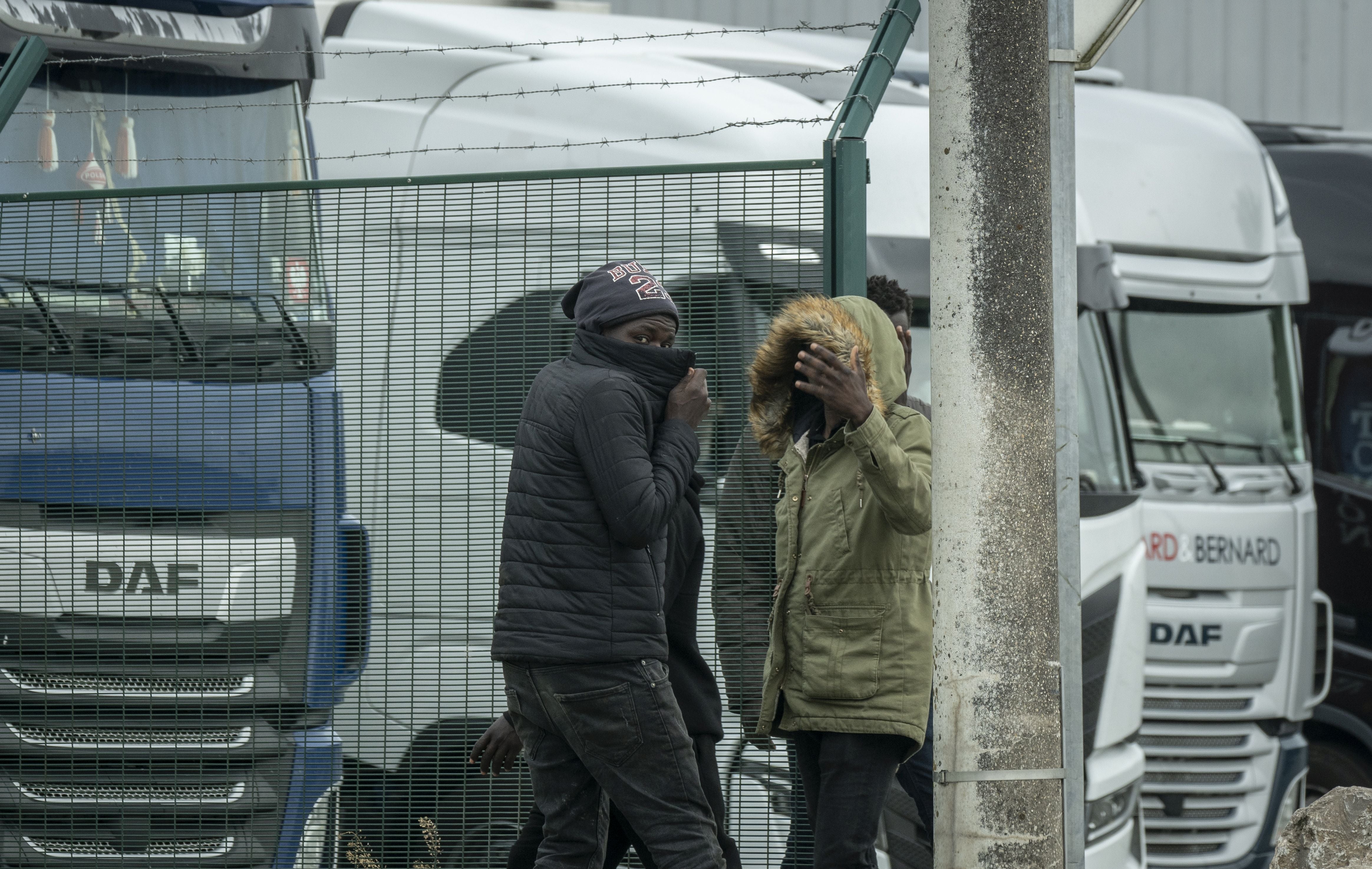 Dos jóvenes intentan colarse en los camiones aparcados. A pesar de que han blindado el paso de los vehículos, es la oportunidad de pasar el canal sin pagar