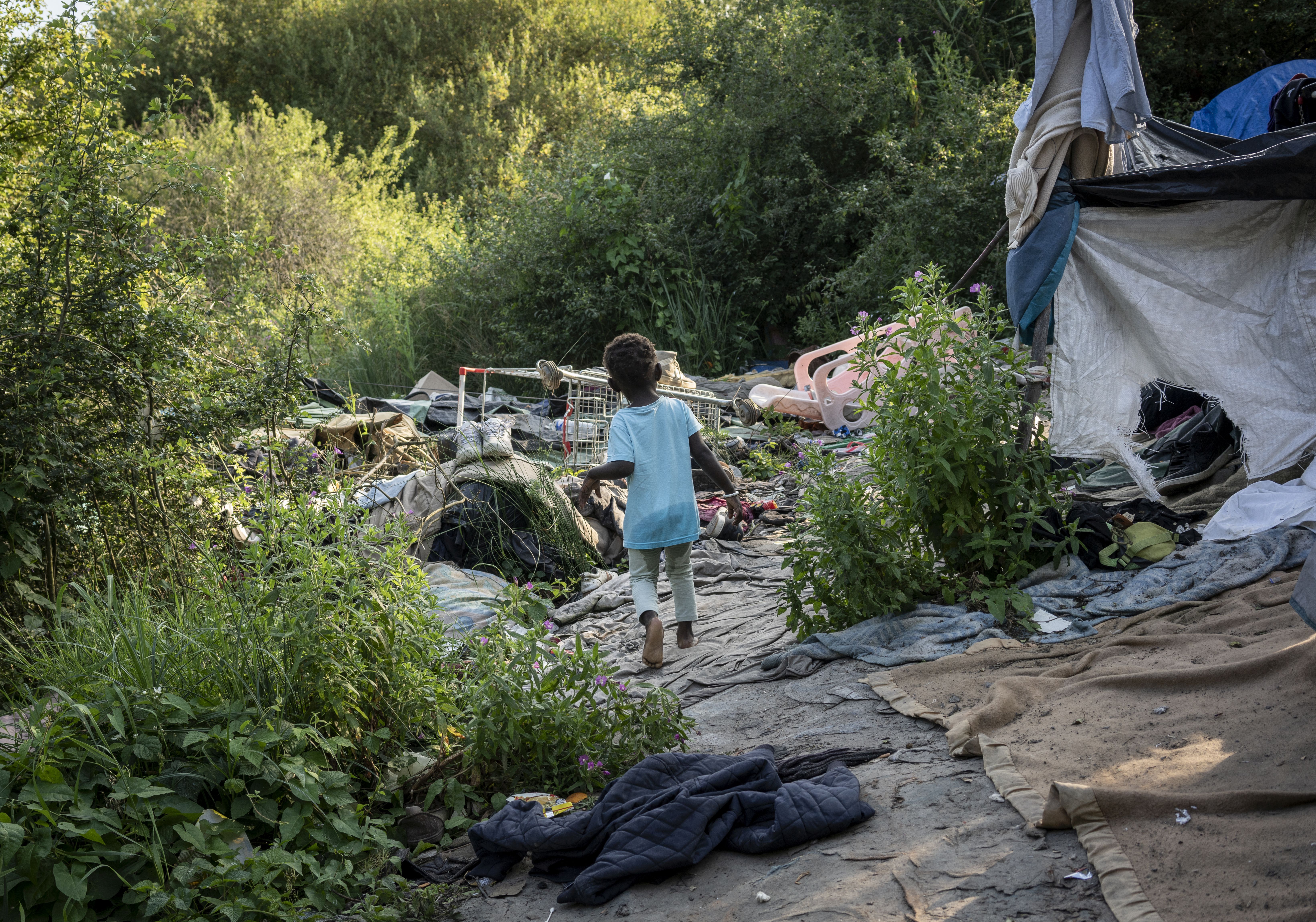 Un niño camina por el campamento de inmigrantes de Grande-Synthe