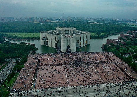 Imagen secundaria 1 - Después de quince años de Gobierno, las protestas de los estudiantes en Bangladés han derrocado a la primera ministra Sheikh Hasina (imagen superior), quien huyó a la India el día que los manifestantes asaltaron el Parlamento (arriba a la izquierda). Una revolución que han presenciado los españoles Guillermo G. Díaz-Ambrona y Jeanine Bello Gastón, quienes estaban de vacaciones por el país y han sido testigos de este momento histórico lleno de tensión por la represión del Ejército (arriba a la derecha) 