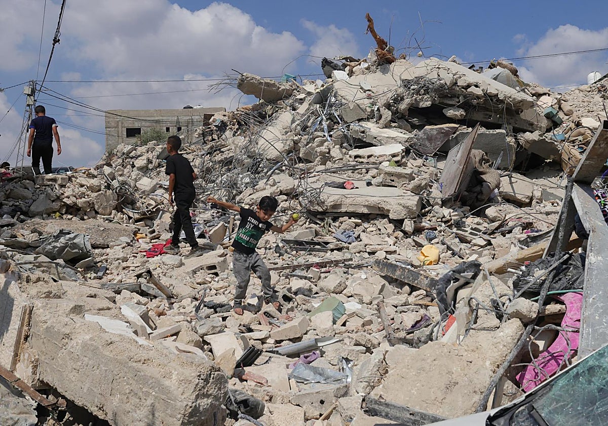 Varios palestinos inspeccionan los daños en un edificio en medio de una operación militar israelí cerca de Yenin