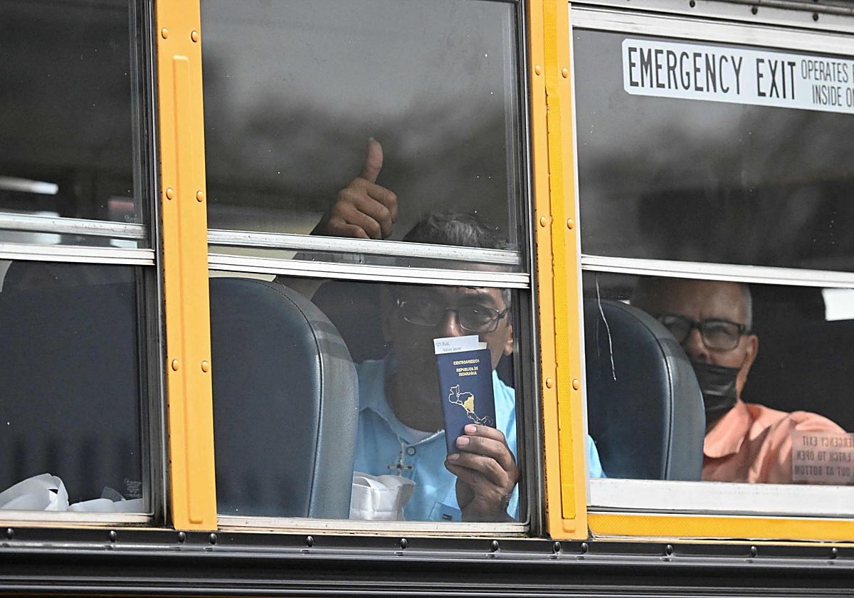 Uno de los presos excarcelados muestra su pasaporte nicargüense mientras abandona el aeropuerto de Ciudad de Guatemala en un autobús
