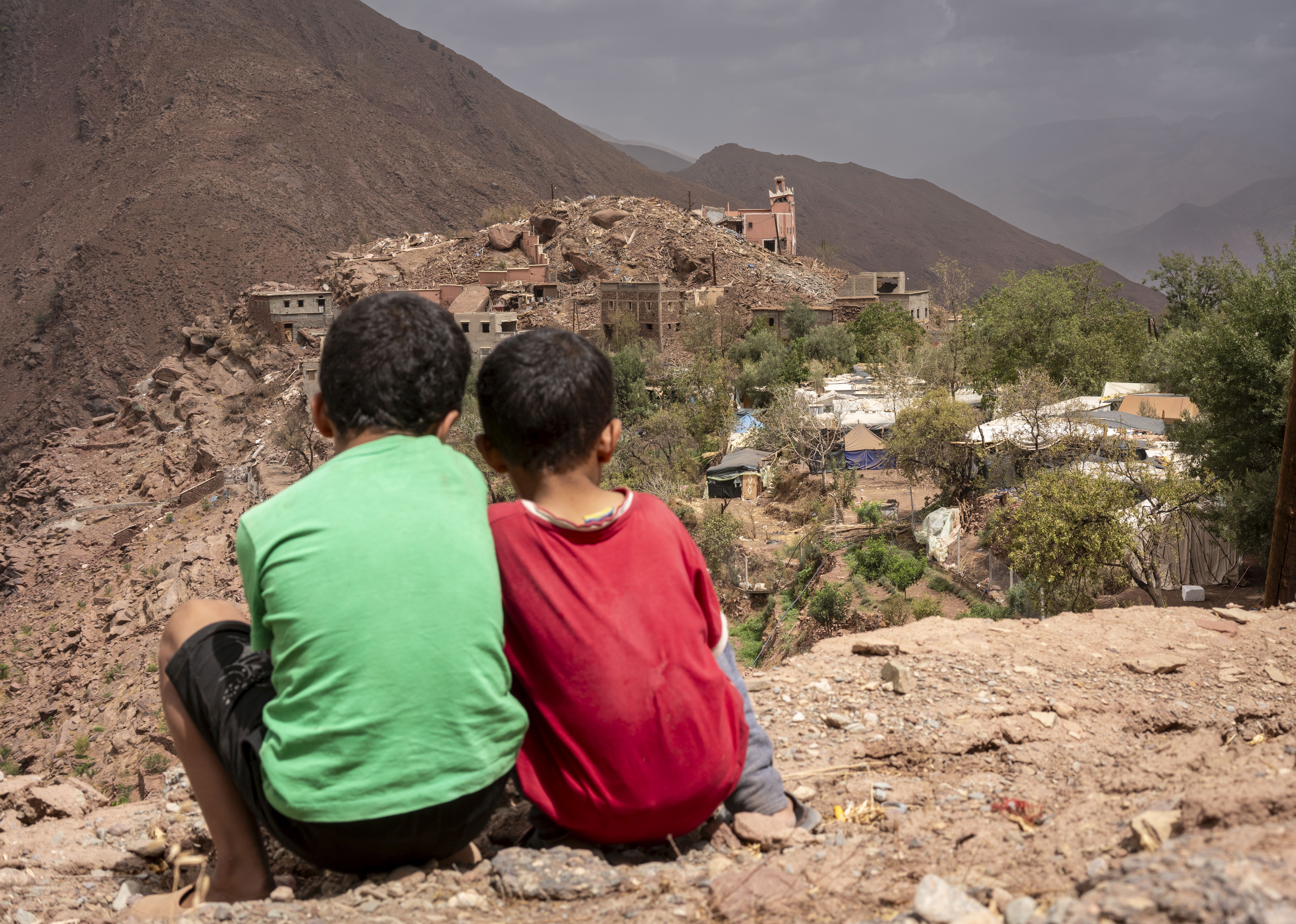 Dos niños miran el pueblo destruido por el terremoto