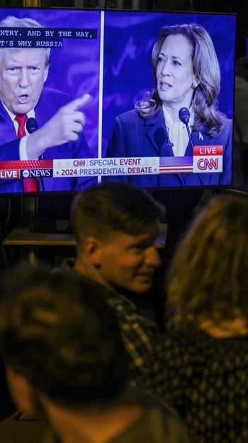 Un grupo de personas sigue el debate entre Trump y Harris en un bar de Washington