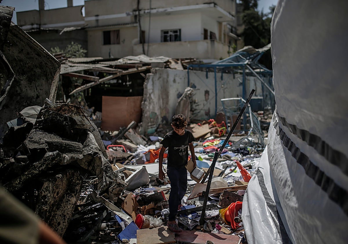 Un niño palestino desplazado internamente inspecciona los escombros en la escuela convertida en refugio dirigida por la UNRWA de al-Jaouni