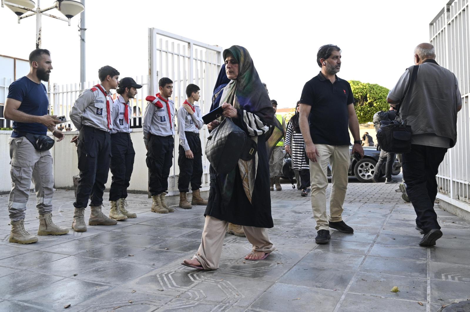 Una mujer llegando con sus pertenencias al refugio establecido en un instituto en Beirut