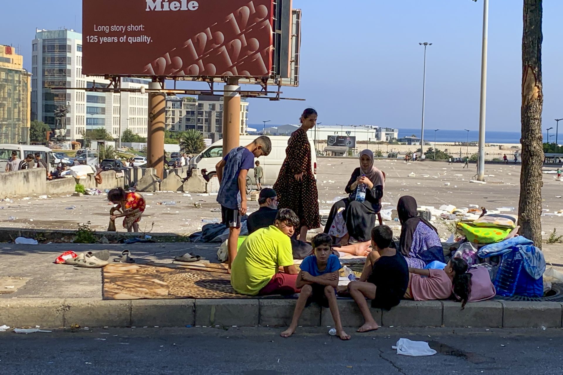 Una familia de desplazados acampa en una plaza de Beirut tras huir de bombardeos israelíes en los suburbios sur de la capital