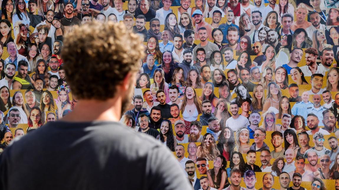 Un joven observa un panel con los rostros de las víctimas