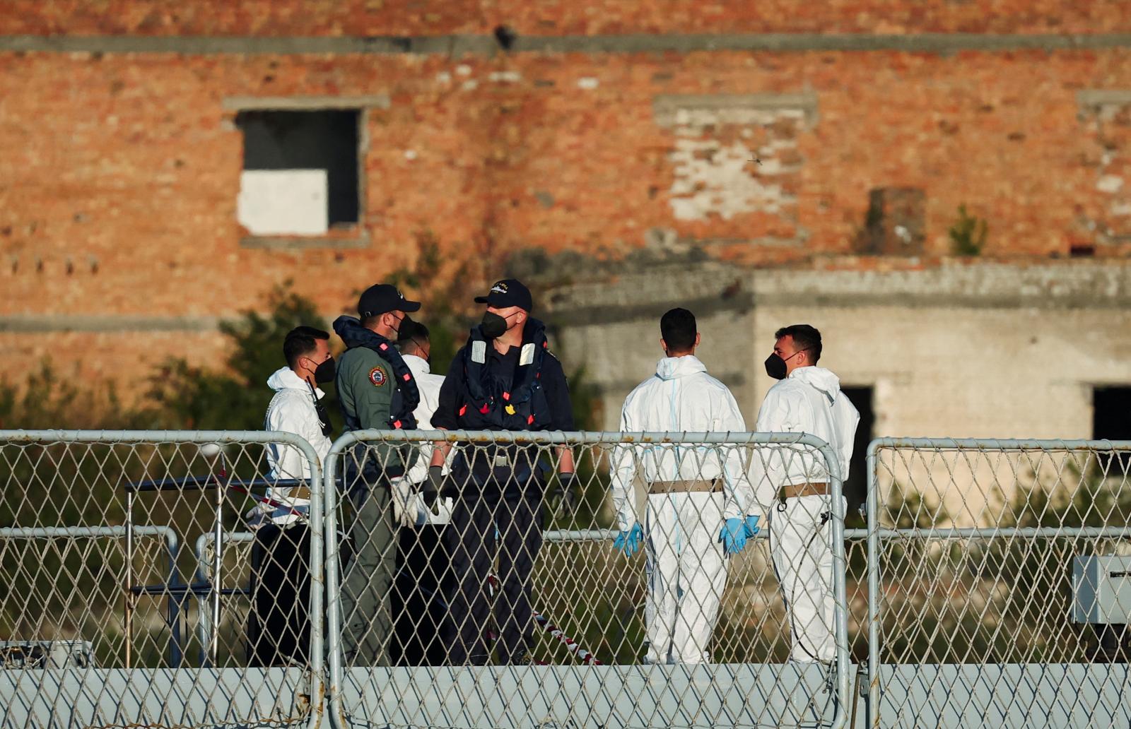 Militares de la marina italiana esperando la llegada de los inmigrantes