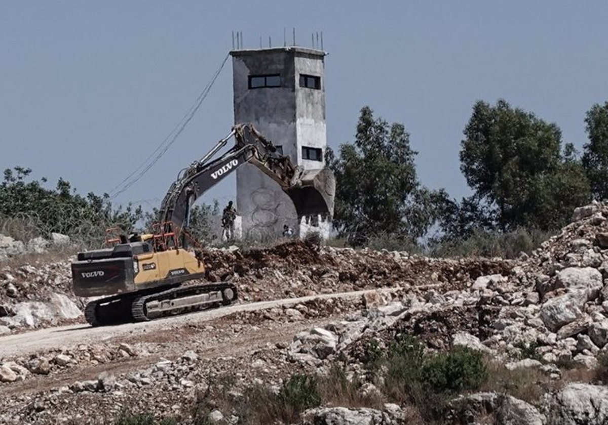 Una excavadora frente a un torre de Finul en una imagen de archivo