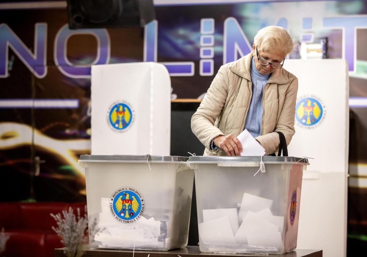 Una mujer deposita su voto en un colegio electoral en el pueblo de Hrusevo, Moldavia