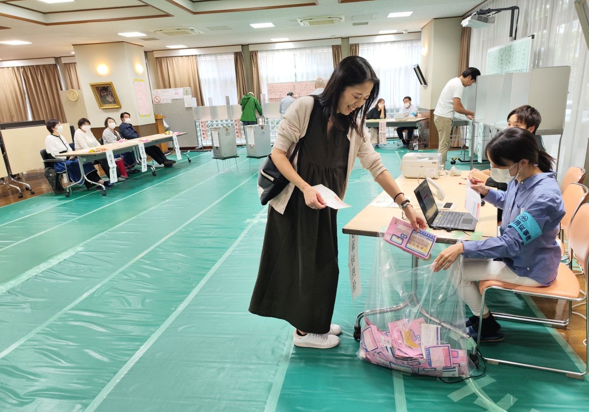 Una mujer se prepara para votar en un colegio electoral de Roppongi, en Tokio