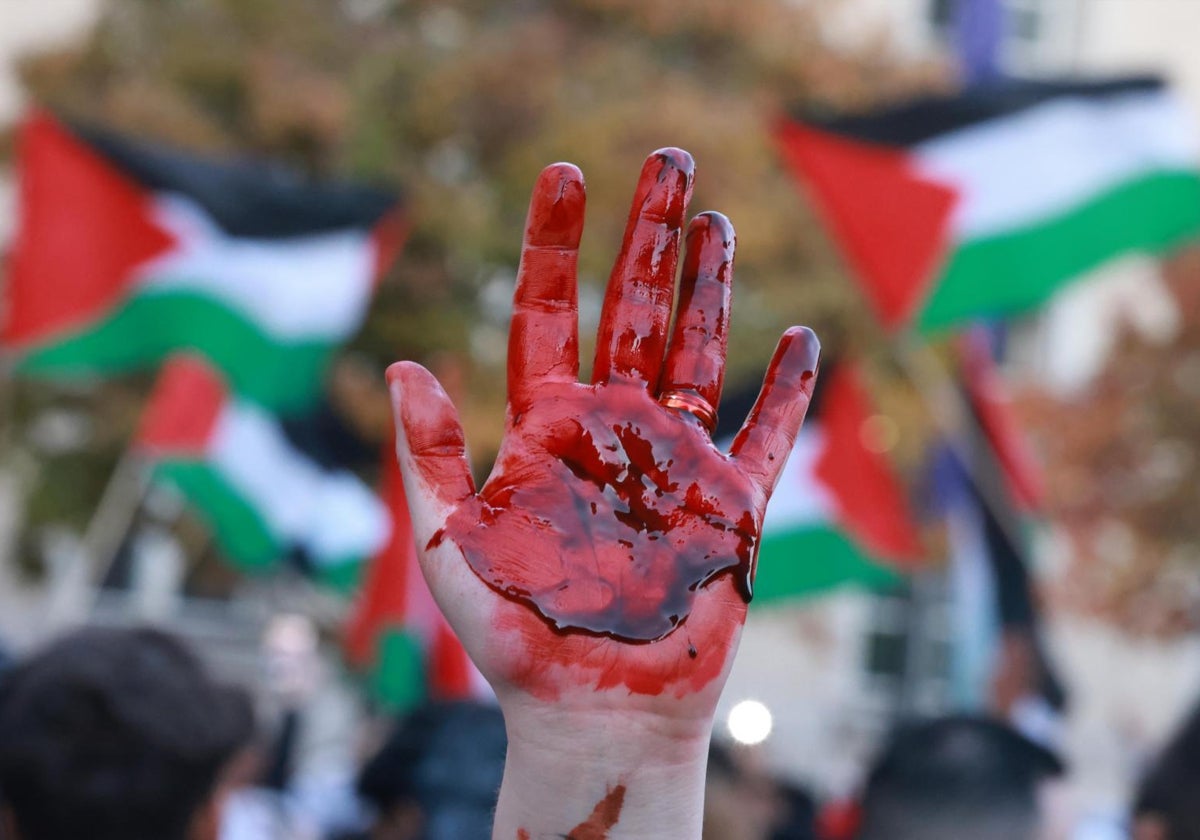 Un manifestante levanta su mano cubierta con sangre artificial durante una protesta propalestina en Berlín