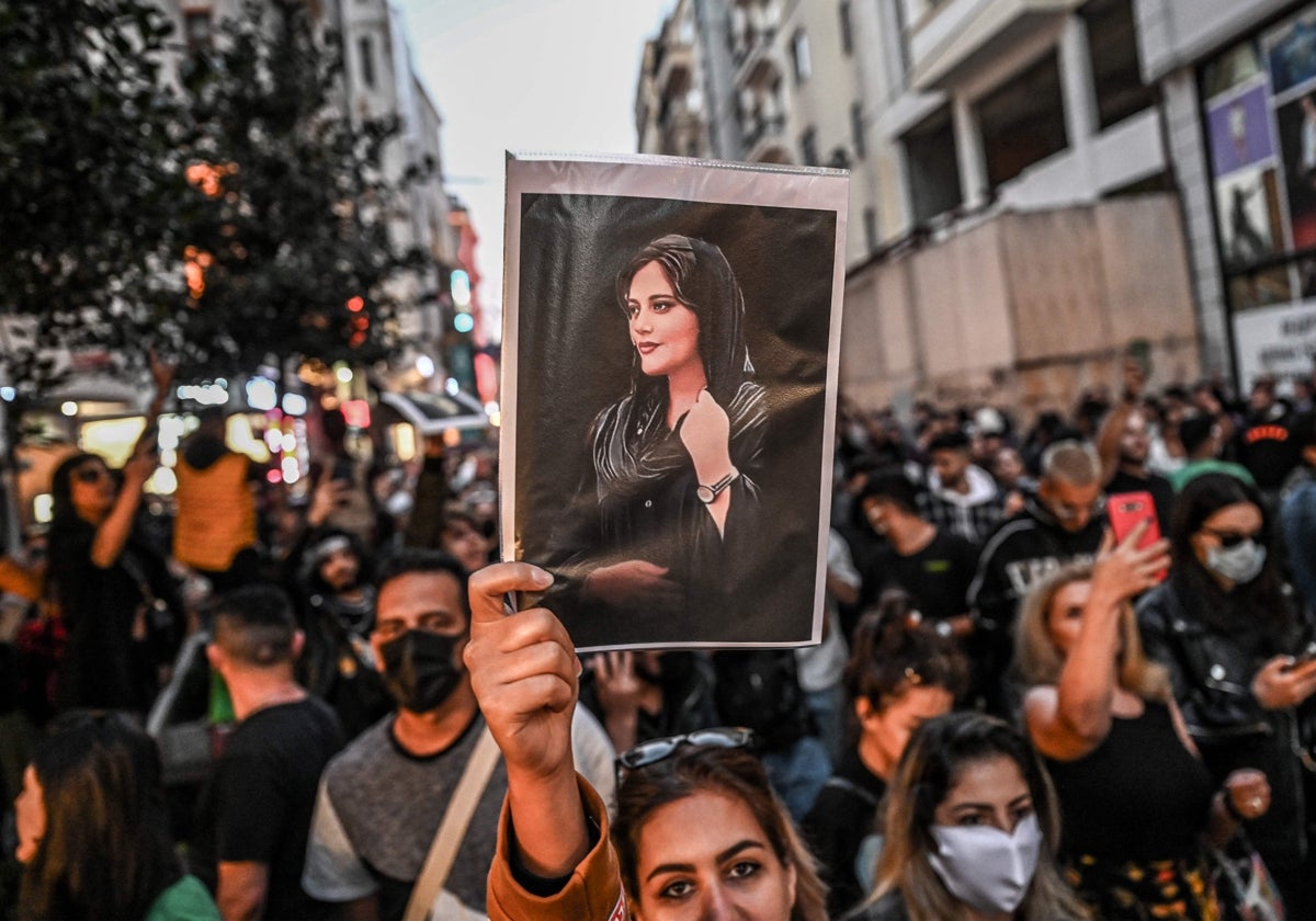 Un manifestante sostiene un retrato de Mahsa Amini durante una protesta en apoyo de la joven iraní en Estambul