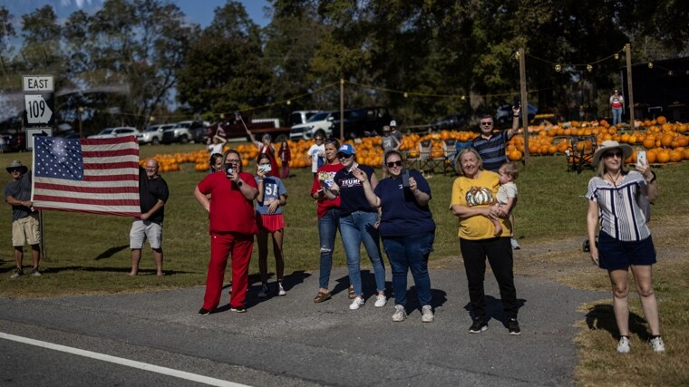 Simpatizantes del candidato presidencial republicano y expresidente de Estados Unidos Donald Trump observan la caravana de Trump cerca de Zebulon, Georgia